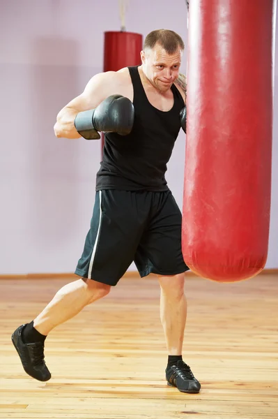 Boxer man at boxing training with heavy bag — Stock Photo, Image