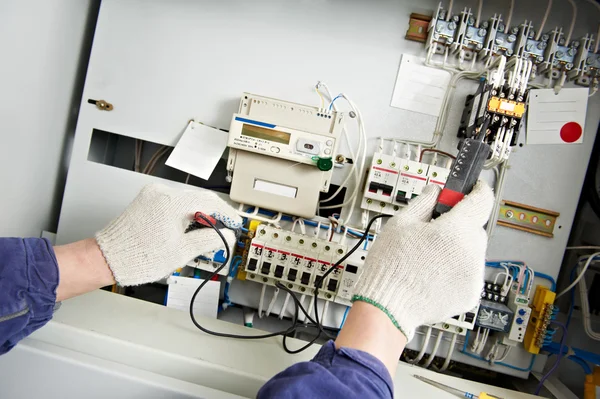 Primer plano Las manos del electricista miden el voltaje — Foto de Stock