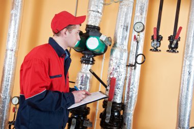 Heating engineer repairman in boiler room clipart