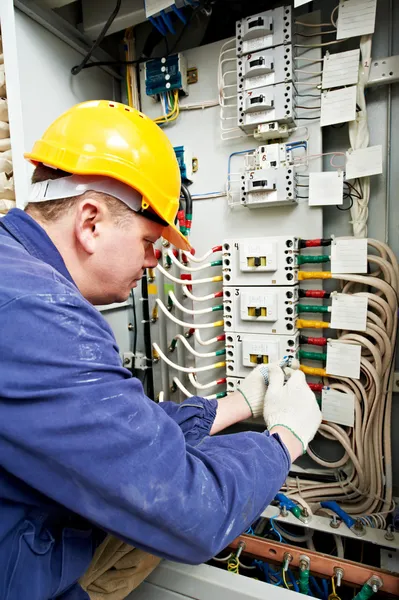 Electricista apriete los tornillos con llave —  Fotos de Stock