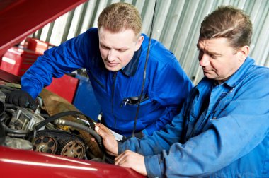 Two car mechanic diagnosing auto engine problem clipart