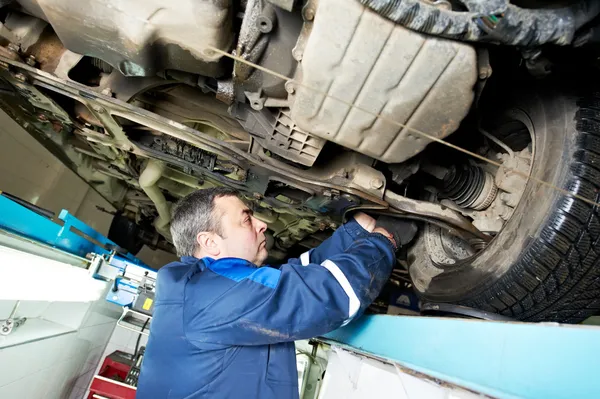Auto mechanic at wheel alignment work with spanner — Stock Photo, Image