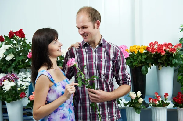 Мужчина и девушка с цветами в магазине на свидании — стоковое фото