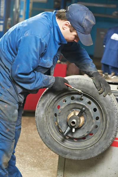 Reparador mecánico en el ajuste de equilibrio de neumáticos —  Fotos de Stock