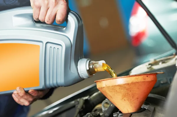 Primer plano mecánico mano verter aceite en el motor del coche —  Fotos de Stock