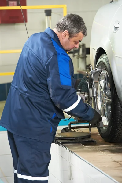 Auto mechanic at wheel alignment work — Stock Photo, Image