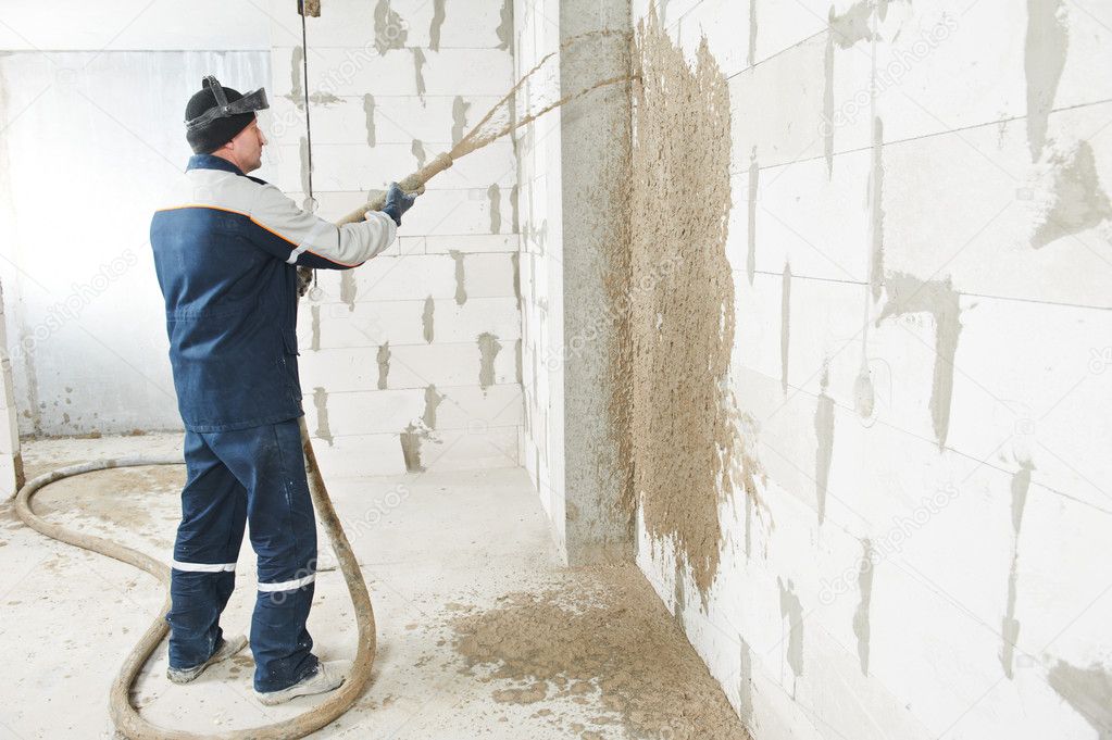 Plasterer at stucco work with liquid plaster