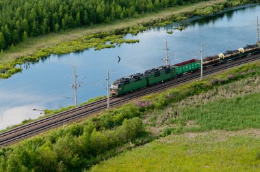 Demiryolu Taşımacılığı. herdem yeşil ağaçların arasındaki yük treni. Havadan görünümü