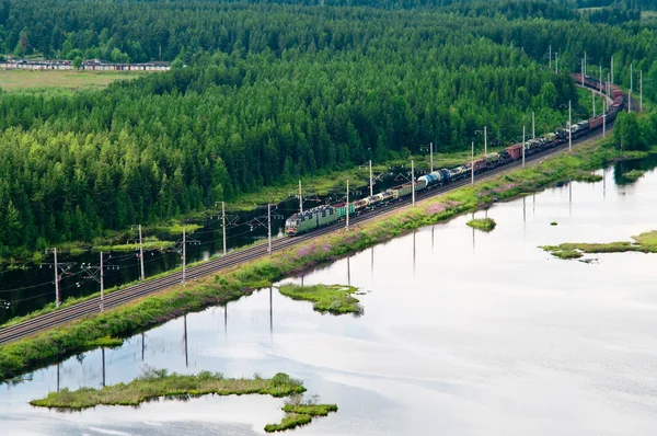 Transporte ferroviario. Tren de carga entre bosques siempreverdes. Vista aérea —  Fotos de Stock