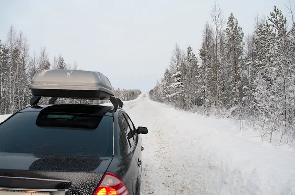 北の森林の冬の雪に覆われた道路で車の旅 — ストック写真