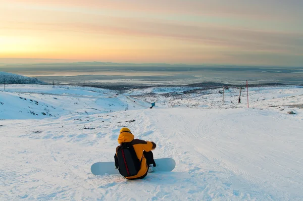 Snowboarder sitting on the mountain slope — Stock Photo, Image