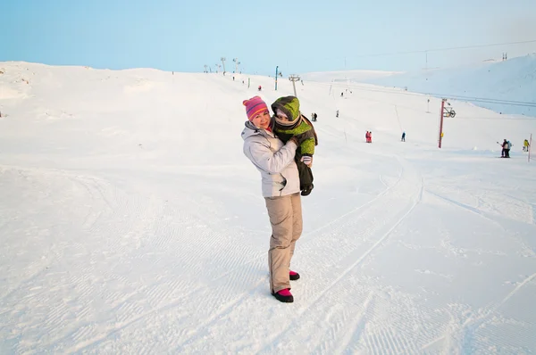 Moeder en klein kind op winter skiresort — Stockfoto
