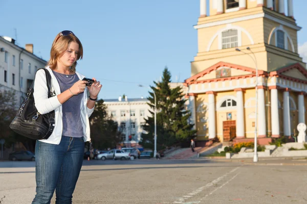 Mladá krásná žena stojící venkovní s fotoaparátem — Stock fotografie