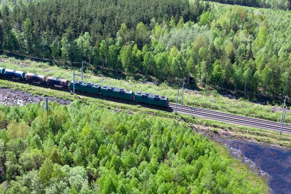 Transporte ferroviario. Tren de carga entre bosques siempreverdes. Vista aérea — Foto de Stock