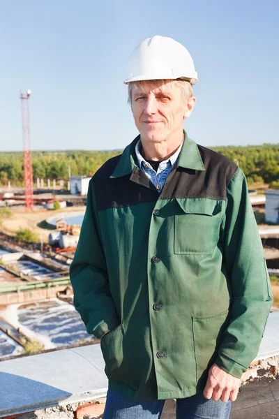 Hombre maduro trabajador manual en hardhat blanco cerca de la cuenca de tratamiento de aguas residuales —  Fotos de Stock