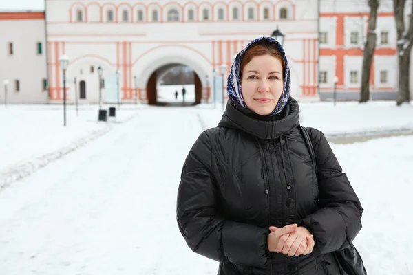 Russian woman in winter clothes against Orthodox monastery building — Stock Photo, Image