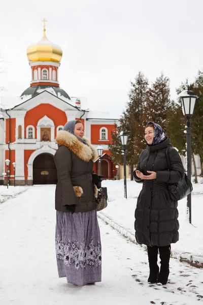 Російських жінок в зимовий одяг проти православний монастир — стокове фото