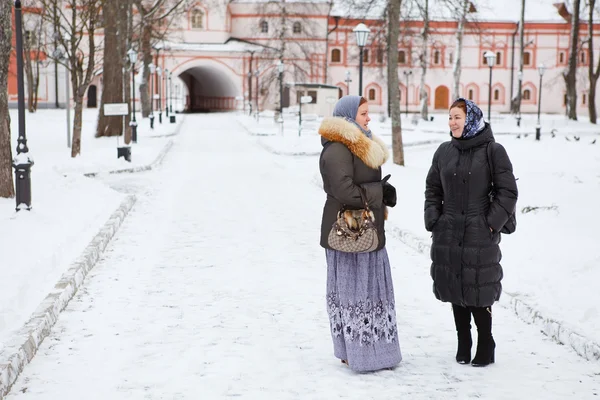 Русские женщины в зимней одежде против православного монастыря — стоковое фото