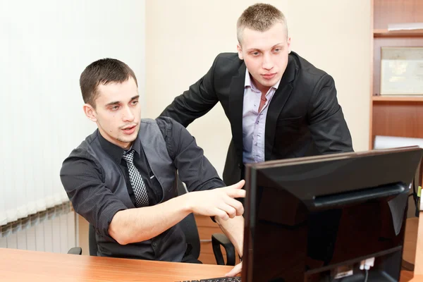 Closeup of young business man pointing at the screen and showing something — Stock Photo, Image