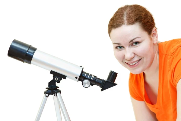 Ung kvinna i orange t-shirt tittar genom teleskop på vit bakgrund — Stockfoto