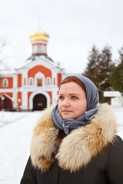 Ryska kvinnliga pilgrim i vinterkläder mot kloster — Stockfoto