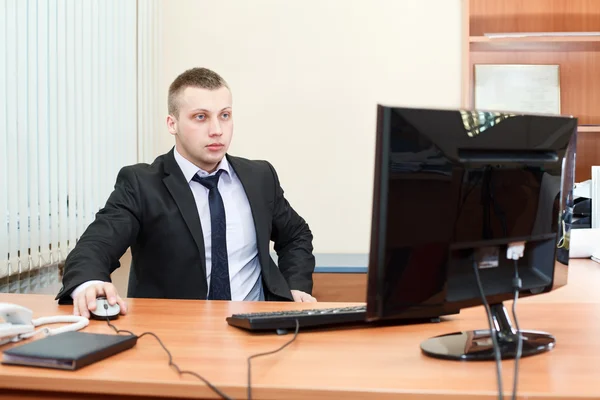 一个聪明的年轻商人，在办公室的计算机上工作的肖像 — 图库照片