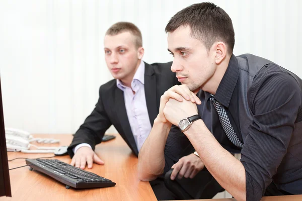 Két üzleti ember, együtt nézi a számítógép képernyőjén — Stock Fotó