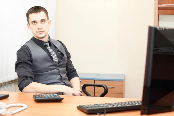 Young business man sitting at table and working on computer — Stock Photo, Image