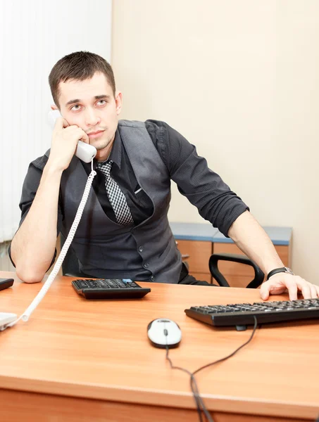 데스크톱 컴퓨터에서 작업 하는 동안 전화에 말하는 스마트 사업 — 스톡 사진