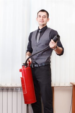 White collar worker with fire-extinguisher in office room clipart