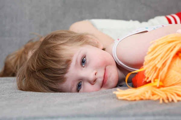 Klein meisje slaapt met doll speelgoed op Bank — Stockfoto