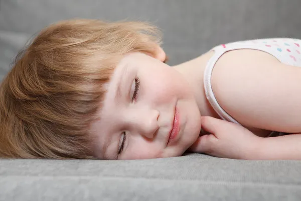 Små kaukasiska flicka sova på soffan. närbild porträtt — Stockfoto