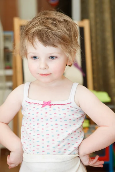 Retrato de menina pequena com cabelo desgrenhado e mãos no corpo — Fotografia de Stock
