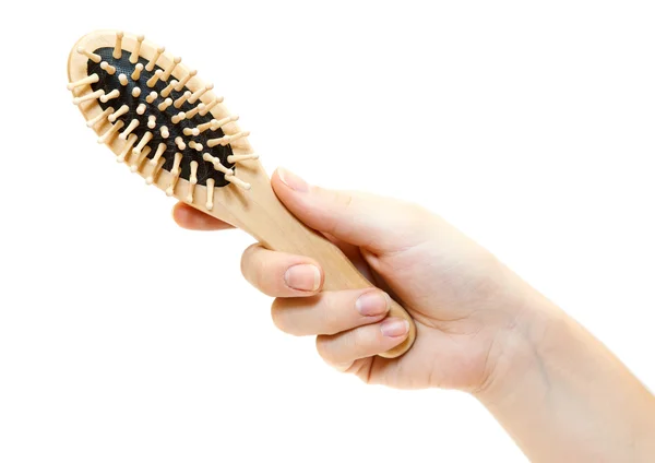 Mão feminina com escova de cabelo de madeira, isolada no fundo branco — Fotografia de Stock