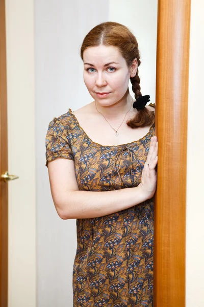 Portret van de jonge Kaukasische vrouw in jurk staande op binnenlandse kamer — Stockfoto