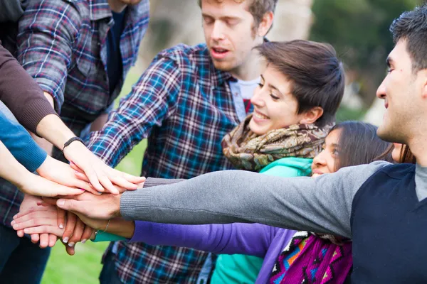 Multiraciale studenten met handen op stapel — Stockfoto