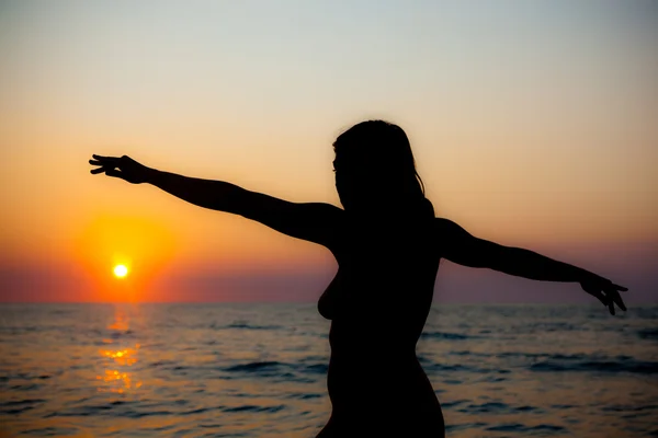 Mulher nua silhueta ao pôr do sol na praia — Fotografia de Stock