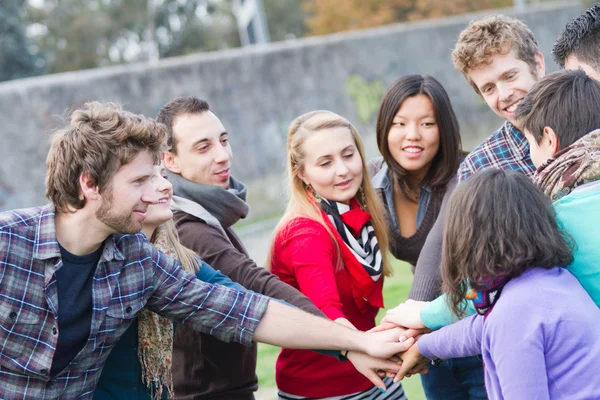 Multirassische Studenten mit Hands on Stack — Stockfoto