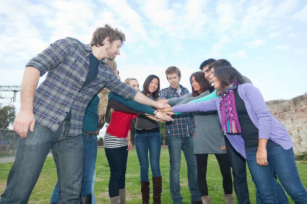 Estudantes multirraciais com as mãos na pilha — Fotografia de Stock