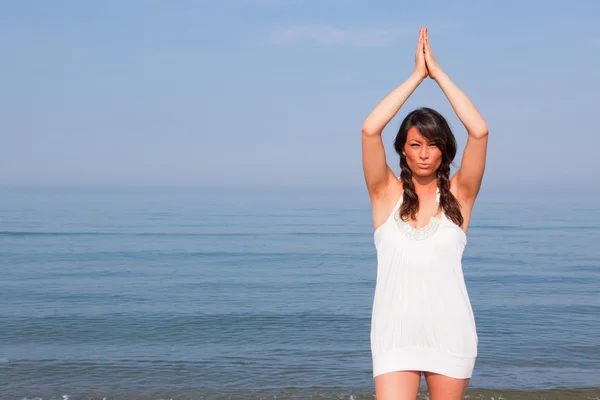 Hermosa joven haciendo ejercicios de yoga en la playa —  Fotos de Stock