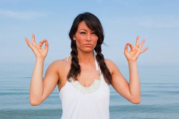 Bella giovane donna che fa esercizi di yoga al mare — Foto Stock