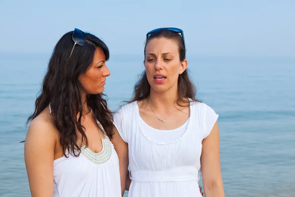 Due amiche abbracciate sulla spiaggia — Foto Stock