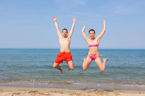 Happy Couple Jumping on the Beach at Seaside — Stock Photo, Image