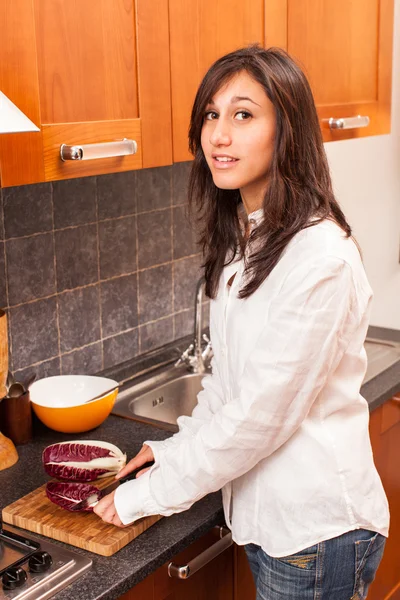 Jovem mulher na cozinha corte de legumes — Fotografia de Stock