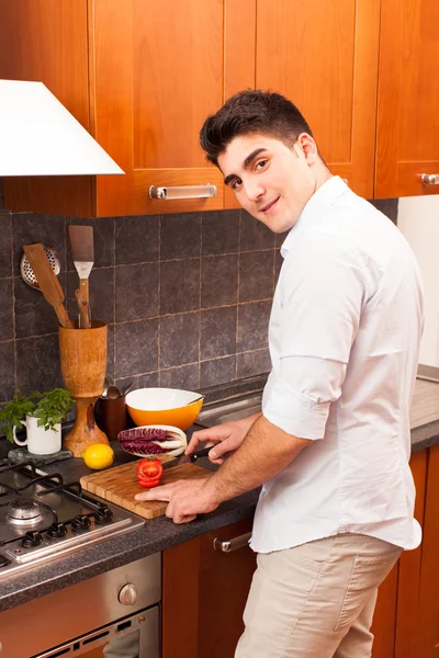 Homem cortando tomate na cozinha — Fotografia de Stock