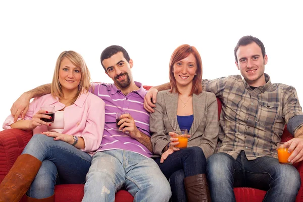 Молодая группа сидит на диване и пьет — стоковое фото