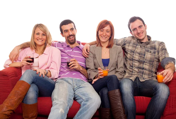 Молодая группа сидит на диване и пьет — стоковое фото