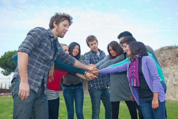 Multirassische Studenten mit Hands on Stack — Stockfoto