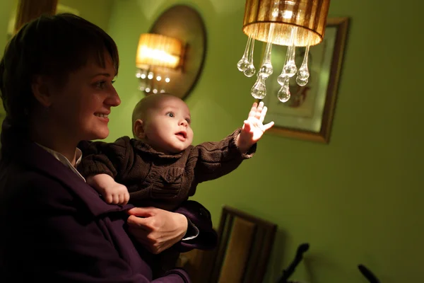 Dítě dotýkat lustr — Stock fotografie