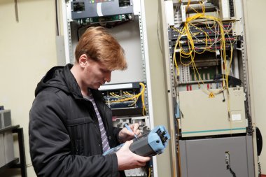 Telecom engineer adjusting reflectometer clipart